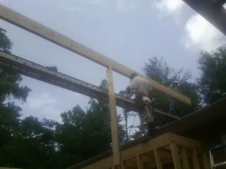 Carpenter setting a ridge beam over a new addition frame — Ice Dam Removal by Roofing Brothers in Overpeck