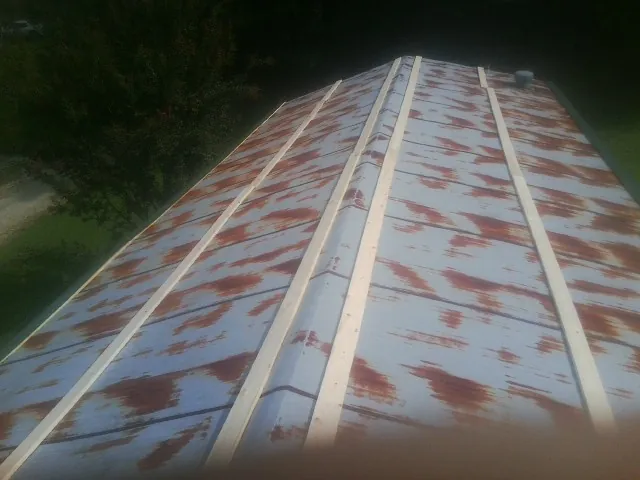 Rusted metal roof panels with new wood purlins before replacement — Storm Damage Roof Repair in Overpeck by Roofing Brothers