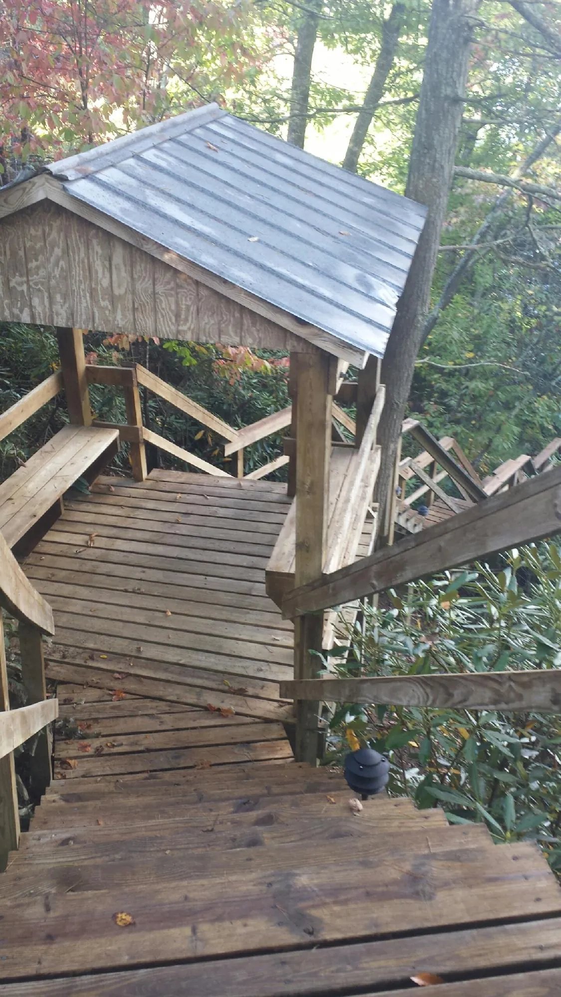 Metal roofed shelter over wooden steps on a wooded walkway — Skylight Repair & Installation work by our crew in Overpeck
